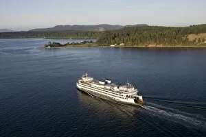 The Washington State ferry Hyak passing by Shaw Island in the evening light, San Juan Islands