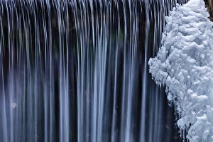Water flowes by ice formation along Falls Creek in winter near Nelson, British Columbia
