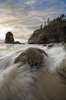 Flowing Prints: Water flowing around the rocks on the beach with sea stacks in the background