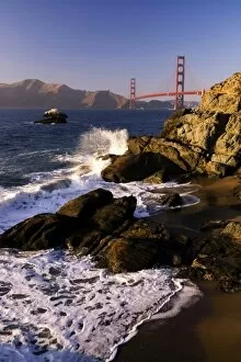 Waves crash on the California coast overlooking the Golden Gate Bridge