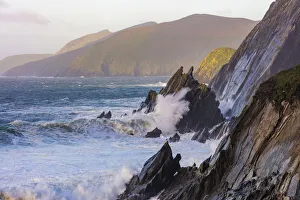Waves crash into cliffs on Dunmore Head with Blasket Islands on the Dingle Peninsula