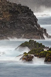 Waves crashing over lava rocks on shoreline of Espanola Island, Galapagos Islands, Ecuador
