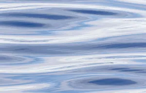 Waves reflecting sky in blue, grey and silver Atlantic ocean near the coast of southern greenland