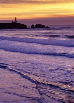 Waves wash in by the Yaquina Head Lighthouse at sunset, near Newport, on the Oregon Coast