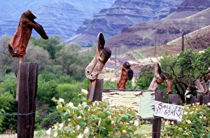 Shoe Prints: Weathered boots; fenceposts; Imanha river canyon, Oregon; rural; humor; footwear