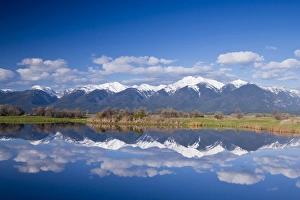 Wetlands pond reflects Mission Mountain Range at Ninepipe WMA near Ronan, Montana, USA
