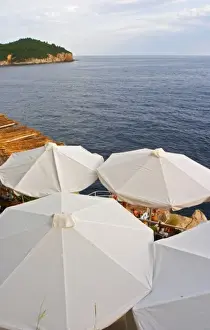 Images Dated 7th July 2006: White sun shade umbrellas at a cafe on the city wall overlooking the sea