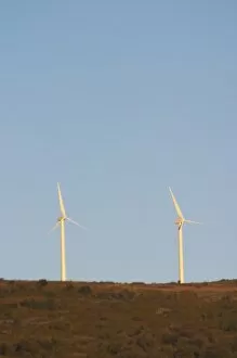 Wind power turbines on a mountain hill top crest against a blue sky. Limoux. Languedoc