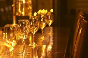 In a wine tasting room glasses lined up on a dark wooden table in golden light, Ulriksdal