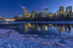 Winter city skyline reflects in the Bow River in Calgary, Alberta, Canada