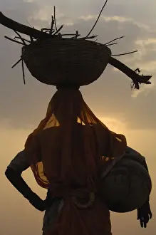 Fair Prints: Woman collecting dung. Camel and cow dung are collected and dried to be used for cooking fires