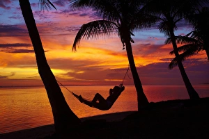 Images Dated 30th October 2011: Woman in hammock, and palm trees at sunset, Coral Coast, Viti Levu, Fiji, South Pacific