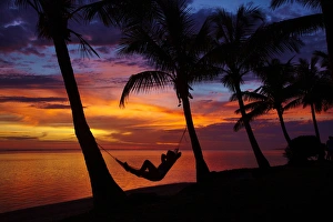 Twilight Prints: Woman in hammock, and palm trees at sunset, Coral Coast, Viti Levu, Fiji, South Pacific