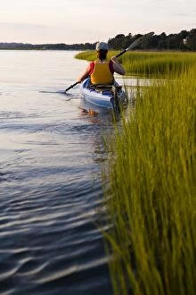 A woman kayaks in a marshy section of the Connecticut River in Old Lyme, Connecticut