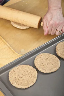 Images Dated 12th February 2019: Woman rolling multigrain bread dough into circles to make hamburger buns. (MR)