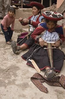 Women in traditional dress and hat weaving using a backstrap loom to weave, Chinchero