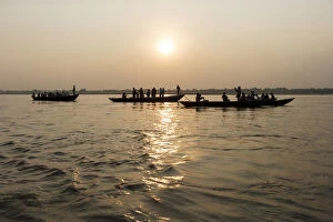 Three wooden boats filled with tourists at sunrise on Ganges river, Varanasi, India