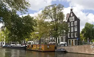 Houseboat Prints: A wooden houseboat with lots o fplants on Prinsengracht Canal