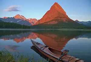 Kayak Prints: Wooden kayak in Swiftcurrent Lake at sunrise in the Many Glacier Valley of Glacier National Park