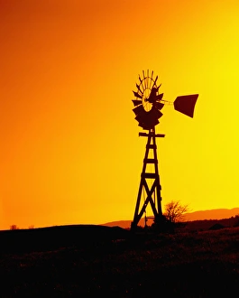 Turbine Prints: A wooden windmill silhouetted agains the setting sun
