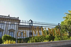 A wrought iron fence and golden letters in the setting sun at at Champagne G.H