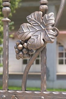Wrought iron grape bunch and vine leaf on the entrance gate to the winery. Podrum