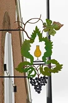Images Dated 10th August 2015: A wrouight iron painted sign that illustrates the theme of champagne and wine production