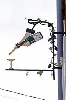 Images Dated 10th August 2015: A wrouight iron painted sign that illustrates the theme of champagne and wine production