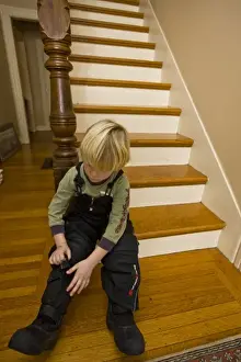 A young boy (age 5) prepares to go outside in the winter in Portsmouth, New Hampshire