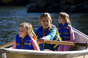 Three young girls (ages 3, 5, 9) in a row boat at Oliver Lodge on Lake Winnipesauke in Meredith