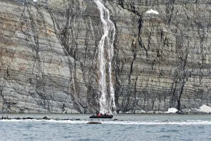 Antarctica Collection: Zodiac approaching waterfall and king penguins on the beach, Gold Harbour, South Georgia